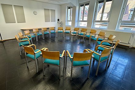 Geschlossener Stuhlkreis mit achtzehn Stühlen