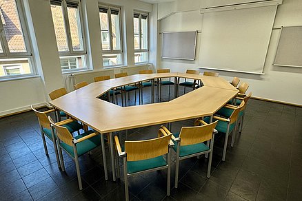Ein Tischquadrat mit insgesamt sechzehn Stühlen