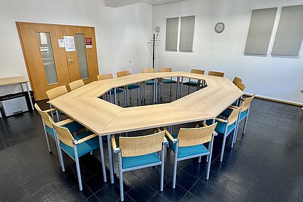 Ein Tischquadrat mit insgesamt sechzehn Stühlen
