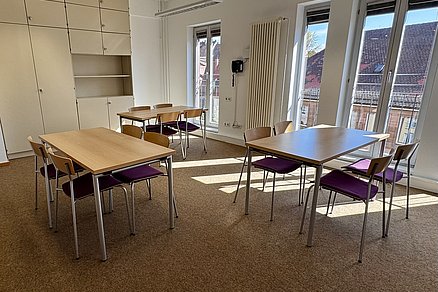 Drei Einzeltische mit jeweils vier sich gegenüberstehenden Stühlen